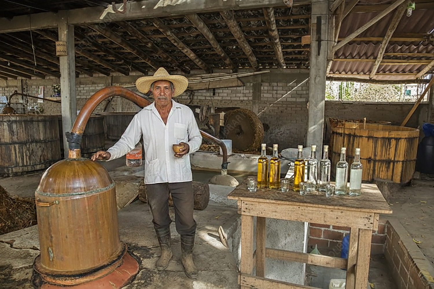 A Maestra Mezcalera stands beside a copper pot still at a traditional palenque in Oaxaca.