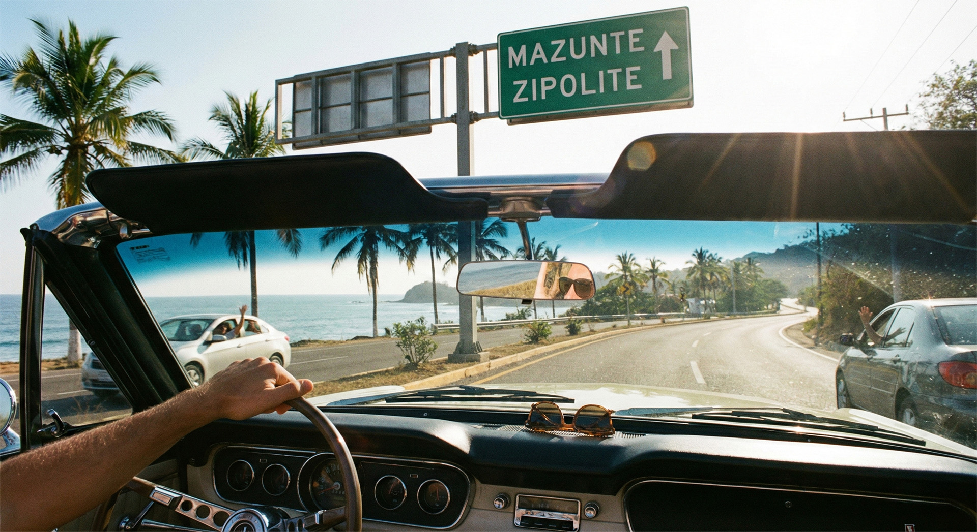 A scenic coastal road winding through lush greenery toward the beaches of Mazunte and Zipolite in Oaxaca